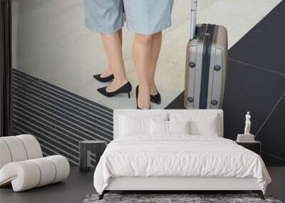 Low section background of two elegant young women wearing heels standing by suitcase in airport, copy space Wall mural