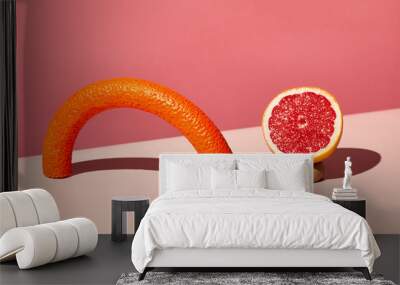 Minimal 3-dimensional composition with fitness equipment and grapefruit against pink background, sport and dieting concept, copy space Wall mural