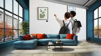 Minimal back view of two schoolboys looking at paintings in modern art gallery, copy space Wall mural