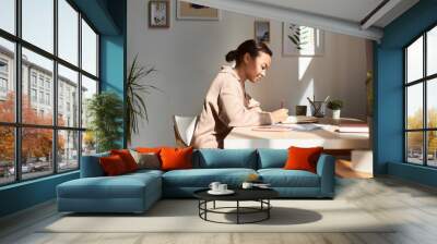 Minimal side view portrait of young African American woman writing in notebook at home with sun rays, copy space Wall mural