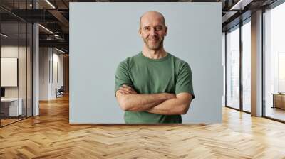 Minimal waist up portrait of mature bald man smiling at camera while standing confidently with arms crossed, copy space Wall mural