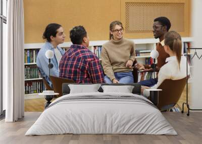 Multi-ethnic group of young people sitting in circle and sharing ideas during class in college, copy space Wall mural