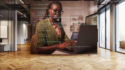 Portrait of contemporary African-American woman using laptop with computer code overlay, copy space Wall mural