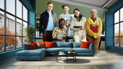 Portrait of diverse creative team looking at camera with cheerful smiles while posing in office, wheelchair user inclusion Wall mural