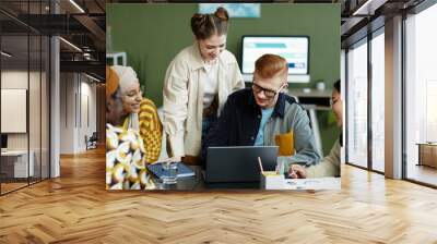 Portrait of diverse creative team using laptop in business meeting enjoying work on project together Wall mural