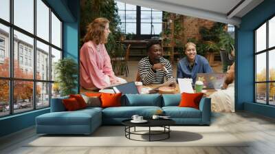 Portrait of diverse successful business team working together at meeting table in green office and smiling copy space Wall mural