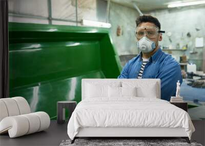 Portrait of handsome workman wearing protective goggles and mask  posing confidently with arms crossed in painting workshop, copy space Wall mural