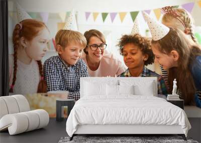 Portrait of happy African-American boy blowing candles on Birthday cake during party  with friends , copy space Wall mural