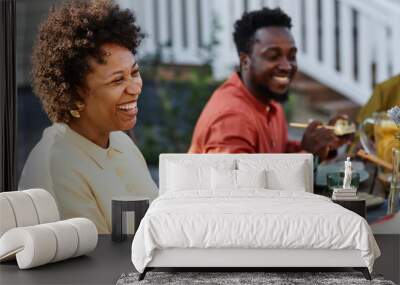 Portrait of happy African American family chatting at dinner table during Summer party outdoors Wall mural