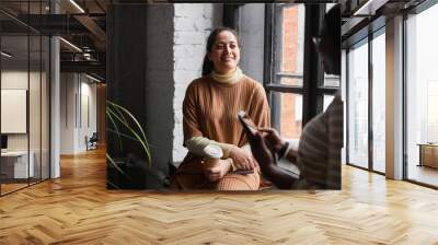 Portrait of Middle-Eastern businesswoman talking to colleague while discussing project in modern office interior, copy space Wall mural