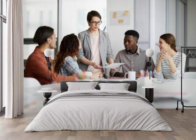 Portrait of successful female manager leading multi-ethnic team in meeting, copy space Wall mural