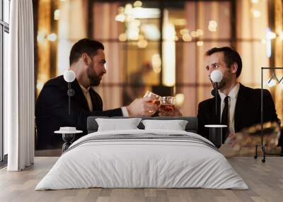 Portrait of two business partners drinking whiskey in restaurant celebrating successful deal, copy space Wall mural