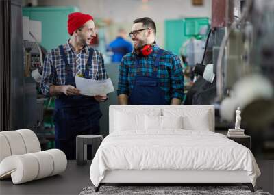 Portrait of two factory workers chatting and smiling standing in industrial workshop, copy space Wall mural