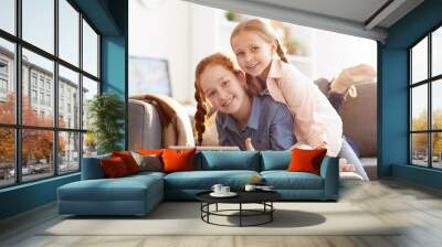 Portrait of two happy loving sisters looking at camera while having fun at home in comfort, copy space Wall mural