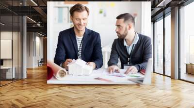 Portrait of two male designers discussing house plans sitting in real estate agency Wall mural