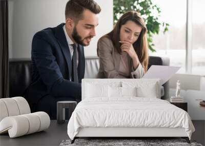 portrait of two modern business people discussing documents in office, focus on pretty young woman r Wall mural