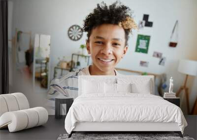 POV of mixed-race teenage boy smiling at camera during video chat or live stream in cozy room, copy space Wall mural