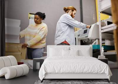 Side view of two workers operating industrial printing machine in shop Wall mural