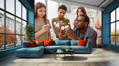 Side view portrait of African American teacher explaining molecule structure to diverse group of children in chemistry class Wall mural