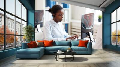 Side view portrait of African-American woman wearing headset and using laptop while working on customer support service, copy space Wall mural