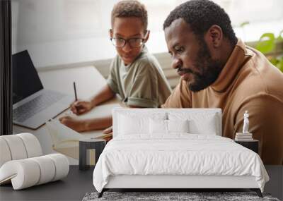 Side view portrait of caring father helping son with homeschooling while studying at home, copy space Wall mural