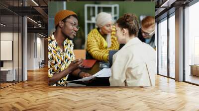 Side view portrait of creative African American man collaborating with team in business meeting Wall mural