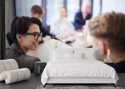 Side view portrait of young businesswoman smiling cheerfully during meeting in conference room, copy space Wall mural