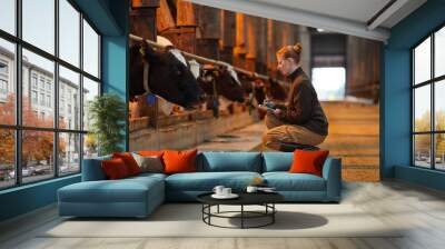 Side view portrait of young woman inspecting livestock and writing on clipboard while working at animal farm, copy space Wall mural