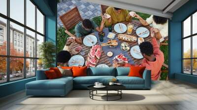 Top view at group of African American people saying grace at picnic table outdoors and holding hands during family gathering Wall mural