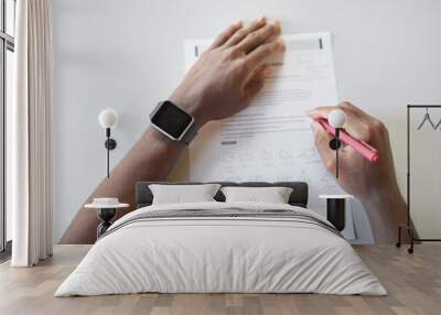 Top view closeup of unrecognizable African-American boy writing in notebook while taking math test in school, focus on smartwatch, copy space Wall mural