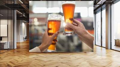 Vertical close up of two workers holding beer glasses while inspecting quality of production and filtration at brewery, copy space Wall mural