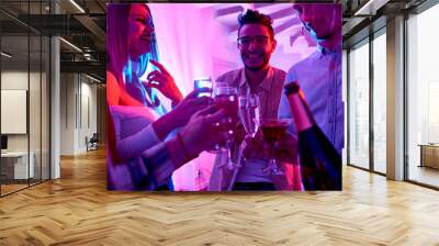 Waist up portrait of group of happy  people enjoying holiday celebration at private house party clinking glasses and toasting Wall mural