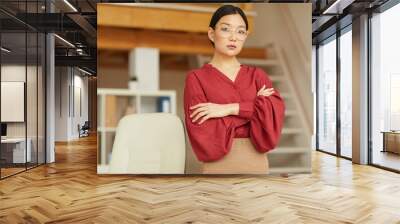 Waist up portrait of successful Asian woman standing with arms crossed while posing in modern office, copy space Wall mural