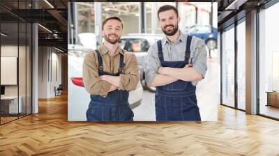 Waist up portrait of two  bearded workers smiling at camera while posing  in production workshop of modern car factory, copy space Wall mural