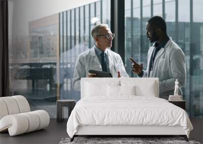 Waist up portrait of two doctors talking while standing by window in conference room, copy space Wall mural