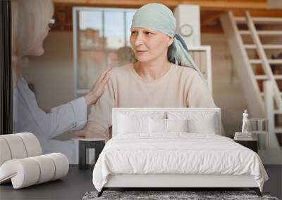 Warm-toned portrait of mature bald woman talking to female doctor comforting and congratulating her during consultation on alopecia and cancer recovery, copy space Wall mural