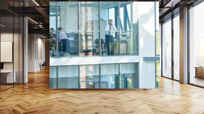 Wide angle portrait of mature businessman speaking by phone standing by floor to ceiling window in modern office building, copy space Wall mural