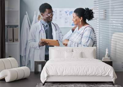 Young African American doctor consulting female patient Wall mural