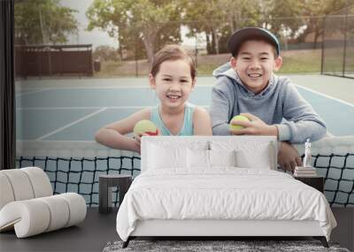 Happy and healthy young mixed Asian children tennis player on outdoor blue court Wall mural