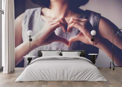 young woman making her hands in heart shape, heart health insurance, social responsibility, donation charity, world heart day, appreciation, world mental health day, stop Asian hate concept Wall mural