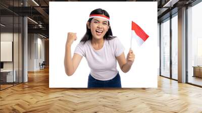 Joyful young Asian woman holding Indonesian flag and celebrating victory with cheerful expression isolated on white background. Indonesian Independence Day Celebration Concept Wall mural