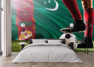 Close up legs of Turkmenistan football team player in red socks, shoes on soccer ball at the free kick or penalty spot playing on grass. Wall mural