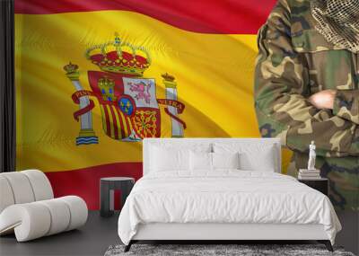 Crossed arms Spanish soldier with national waving flag on background - Spain Military theme. Wall mural