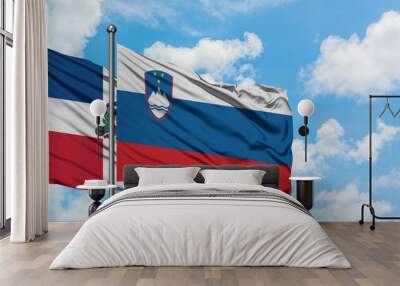 Dominican Republic and Slovenia flag waving in the wind against white cloudy blue sky together. Diplomacy concept, international relations. Wall mural