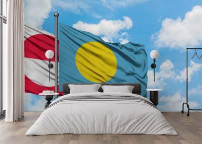 Greenland and Palau flag waving in the wind against white cloudy blue sky together. Diplomacy concept, international relations. Wall mural