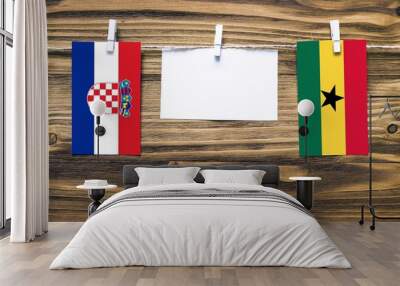 Hanging flags of Croatia and Ghana attached to rope with clothes pins with copy space on white note paper on wooden background.Diplomatic relations between countries. Wall mural