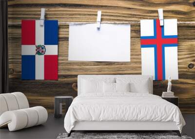 Hanging flags of Dominican Republic and Faroe Islands attached to rope with clothes pins with copy space on white note paper on wooden background.Diplomatic relations between countries. Wall mural