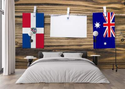 Hanging flags of Dominican Republic and Heard and Mcdonald Islands attached to rope with clothes pins with copy space on white note paper on wooden background.Diplomatic relations between countries. Wall mural