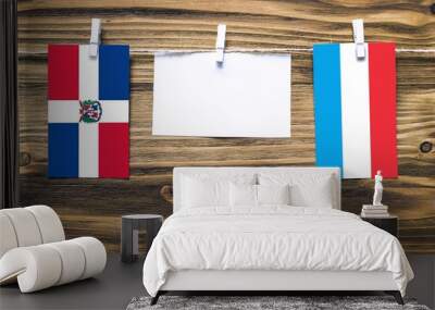 Hanging flags of Dominican Republic and Luxembourg attached to rope with clothes pins with copy space on white note paper on wooden background.Diplomatic relations between countries. Wall mural