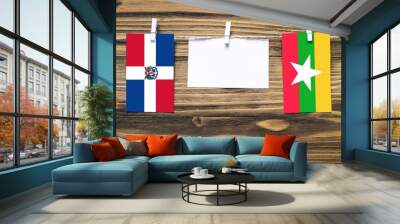 Hanging flags of Dominican Republic and Myanmar attached to rope with clothes pins with copy space on white note paper on wooden background.Diplomatic relations between countries. Wall mural